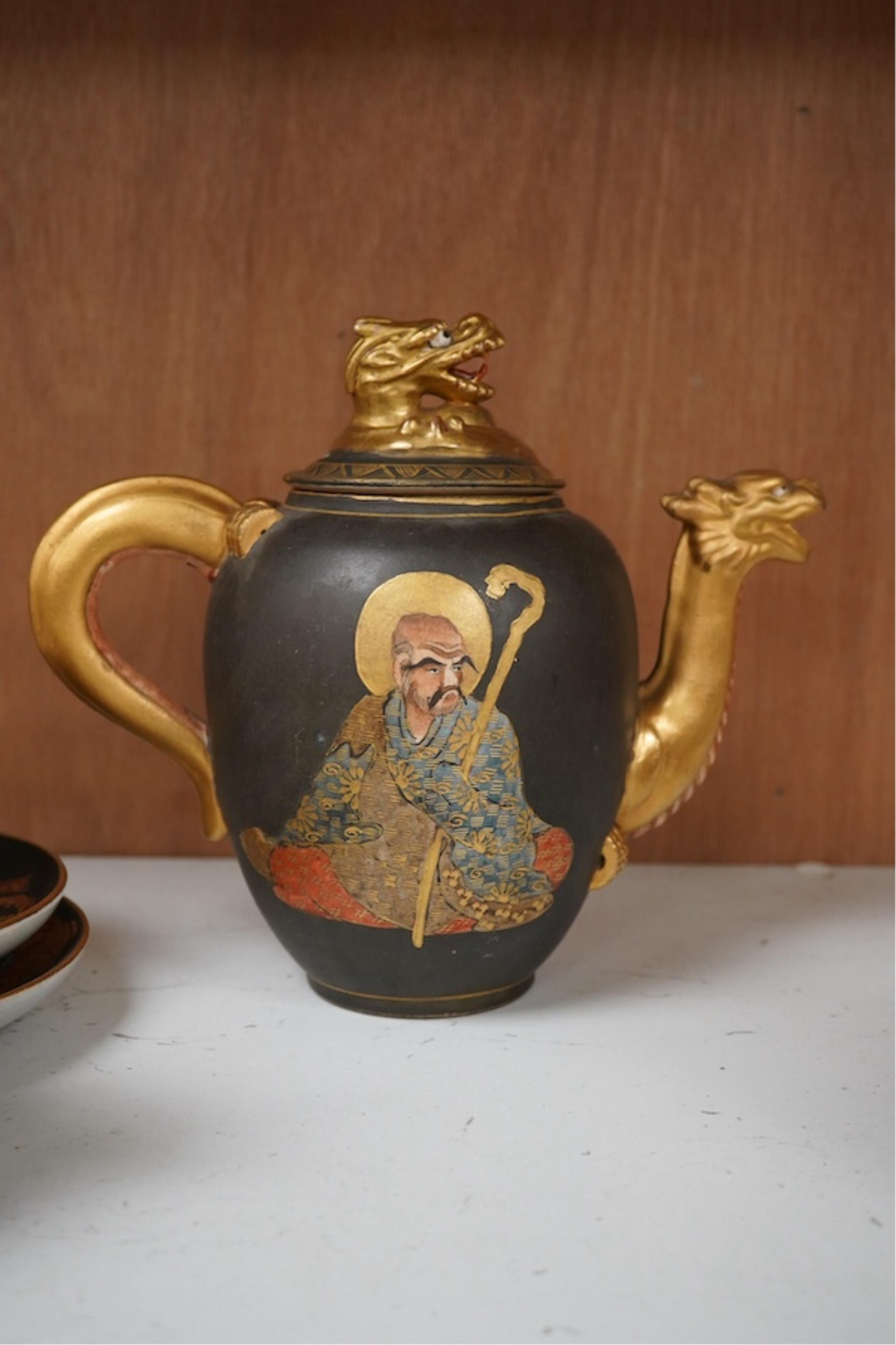 A Japanese Satsuma pottery enamel decorated tea set with Kwannon and rakan, teapot and cover 18cm high. Condition - one cup missing, one cup cracked